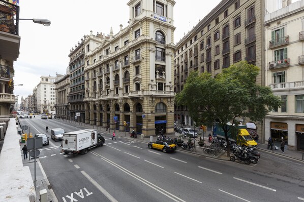 Una calle urbana concurrida con edificios históricos, un taxi y un camión de reparto.
