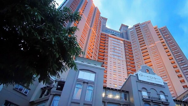Um edifício alto com várias varandas e uma placa indicando 'Grand Def'.