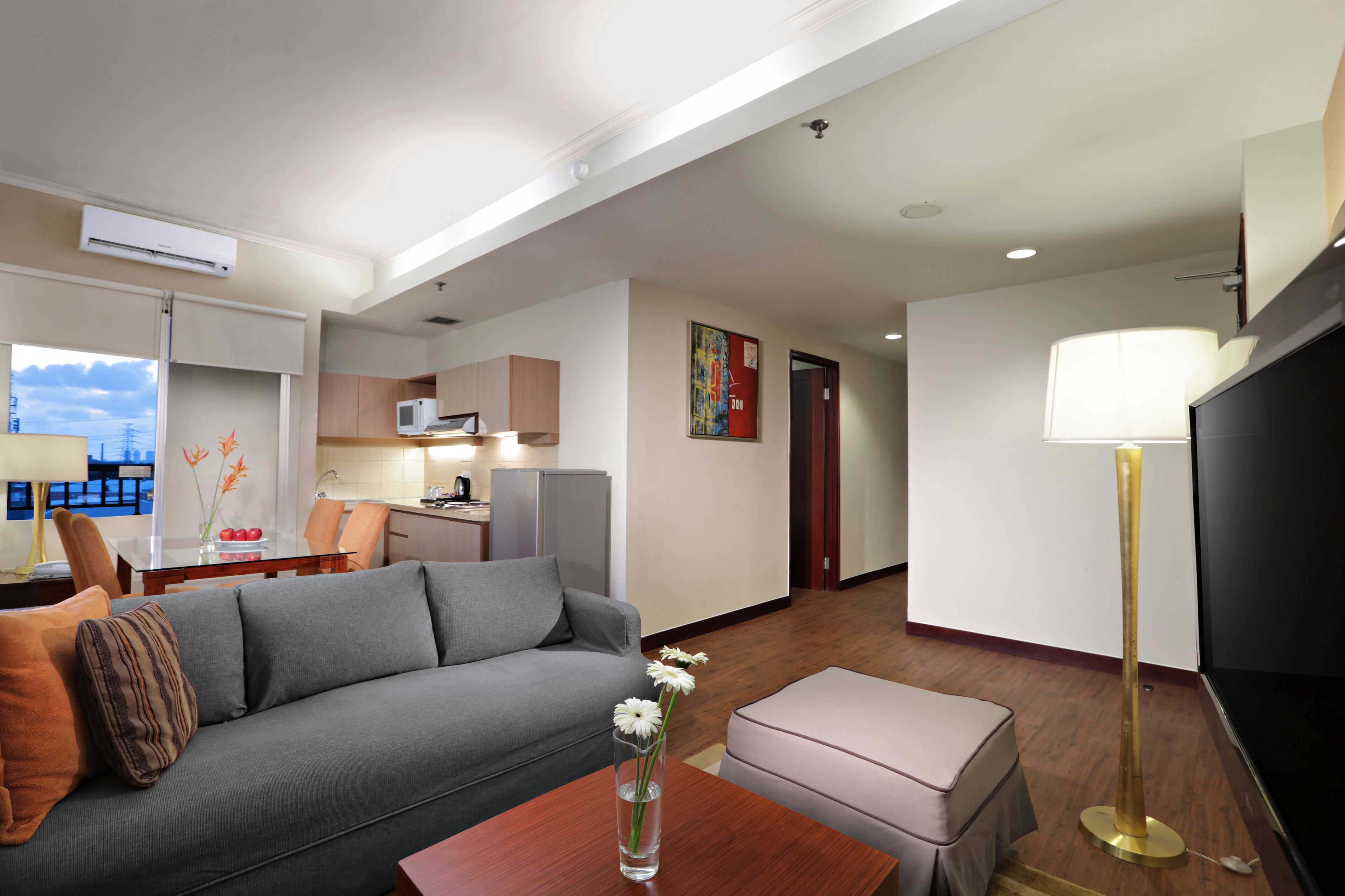 A modern living room with a grey sofa, a wooden coffee table, and a TV.