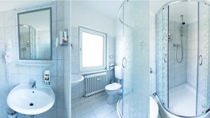 A bathroom with a sink, toilet, and shower. - Kallmeyer (Berlin)