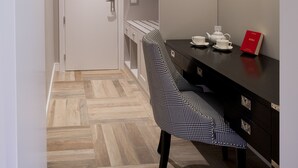 Cuina moderna amb taulell negre, una cadira i una làmpada penjant.