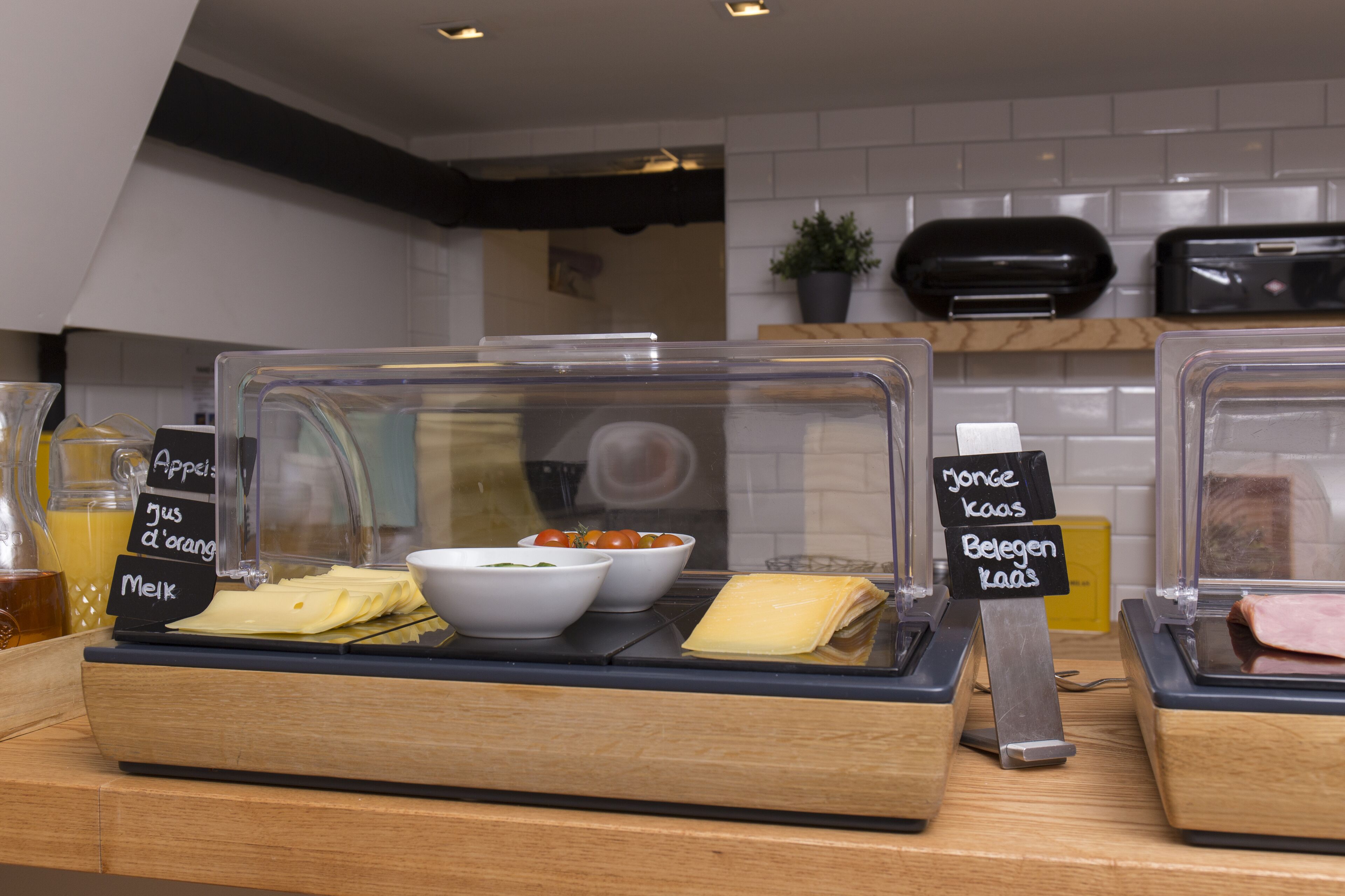 A breakfast display with various food items and labels in a cafe setting.