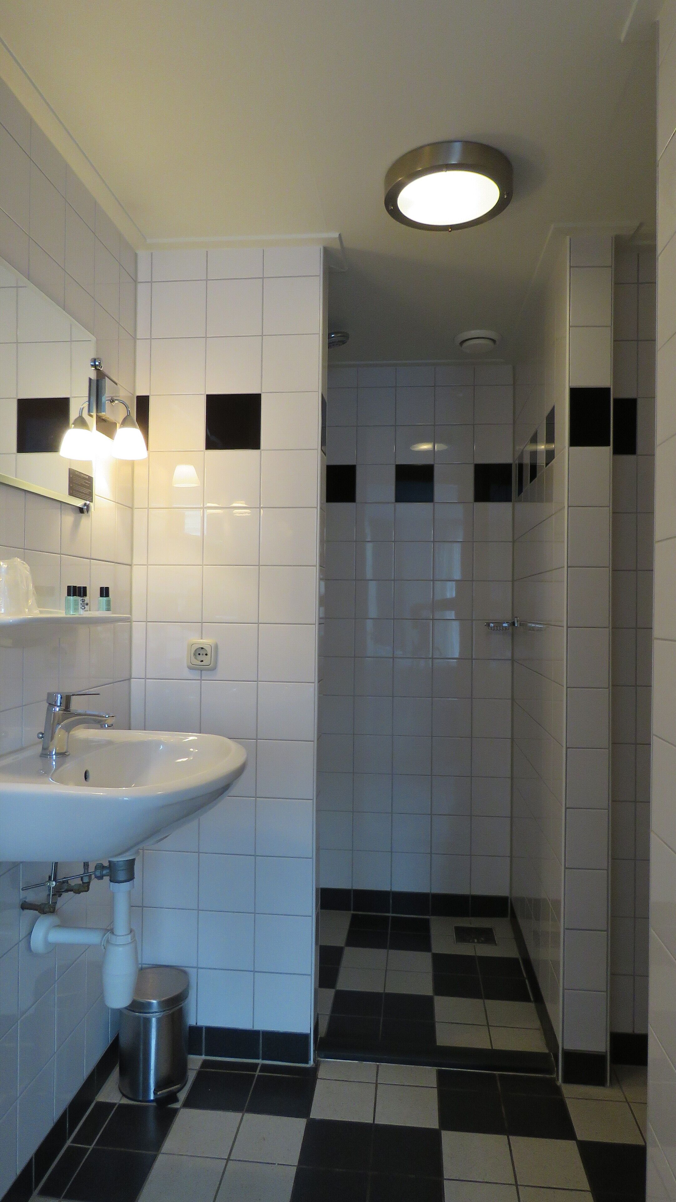 A bathroom with a sink, mirror, and two wall-mounted lights.