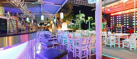 Eine Bar mit einer langen Theke, mehreren Stühlen und Tischen zum Essen.