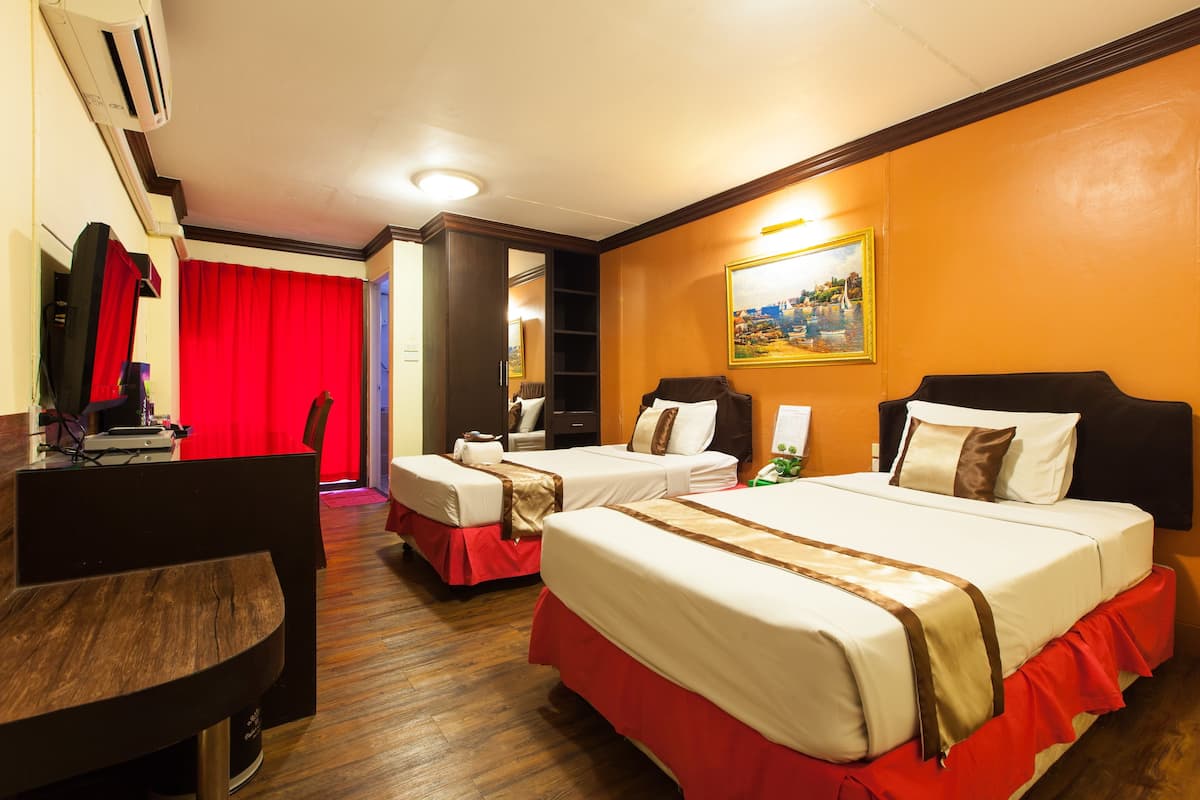 Ein Hotelzimmer mit zwei Betten, einem Schreibtisch und einem Stuhl.