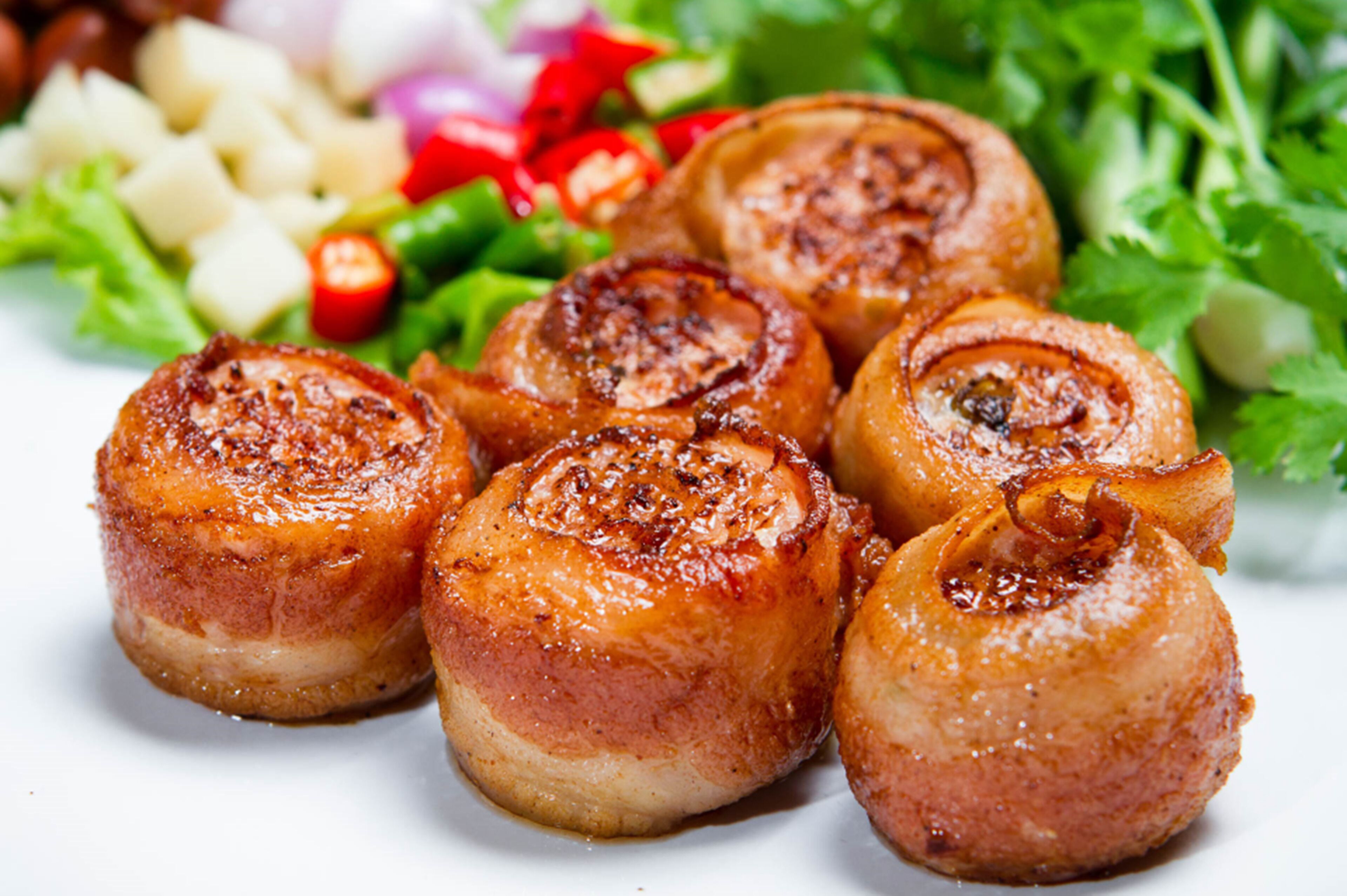 Ein Teller gegrillte Jakobsmuscheln mit dazu Gemüse.