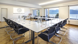 Ein Konferenzraum mit einem langen Tisch, Stühlen und Blick aufs Meer.