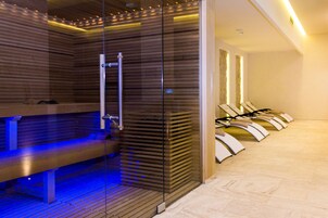Una sauna con bancos y un separador de vidrio.