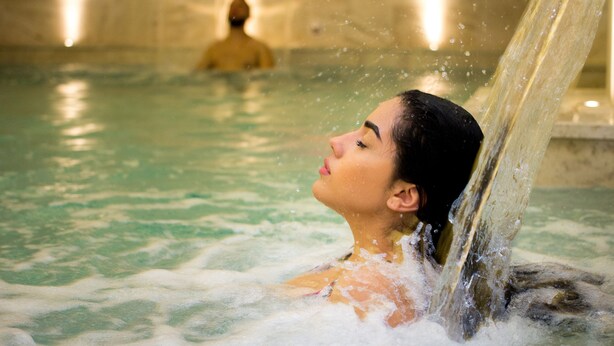 A person in a hot tub with water flowing over them. - Granduca (Grosseto)