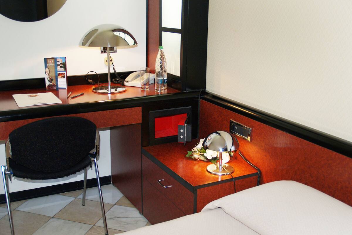 Een hotelkamer met een bureau, stoel en bed.