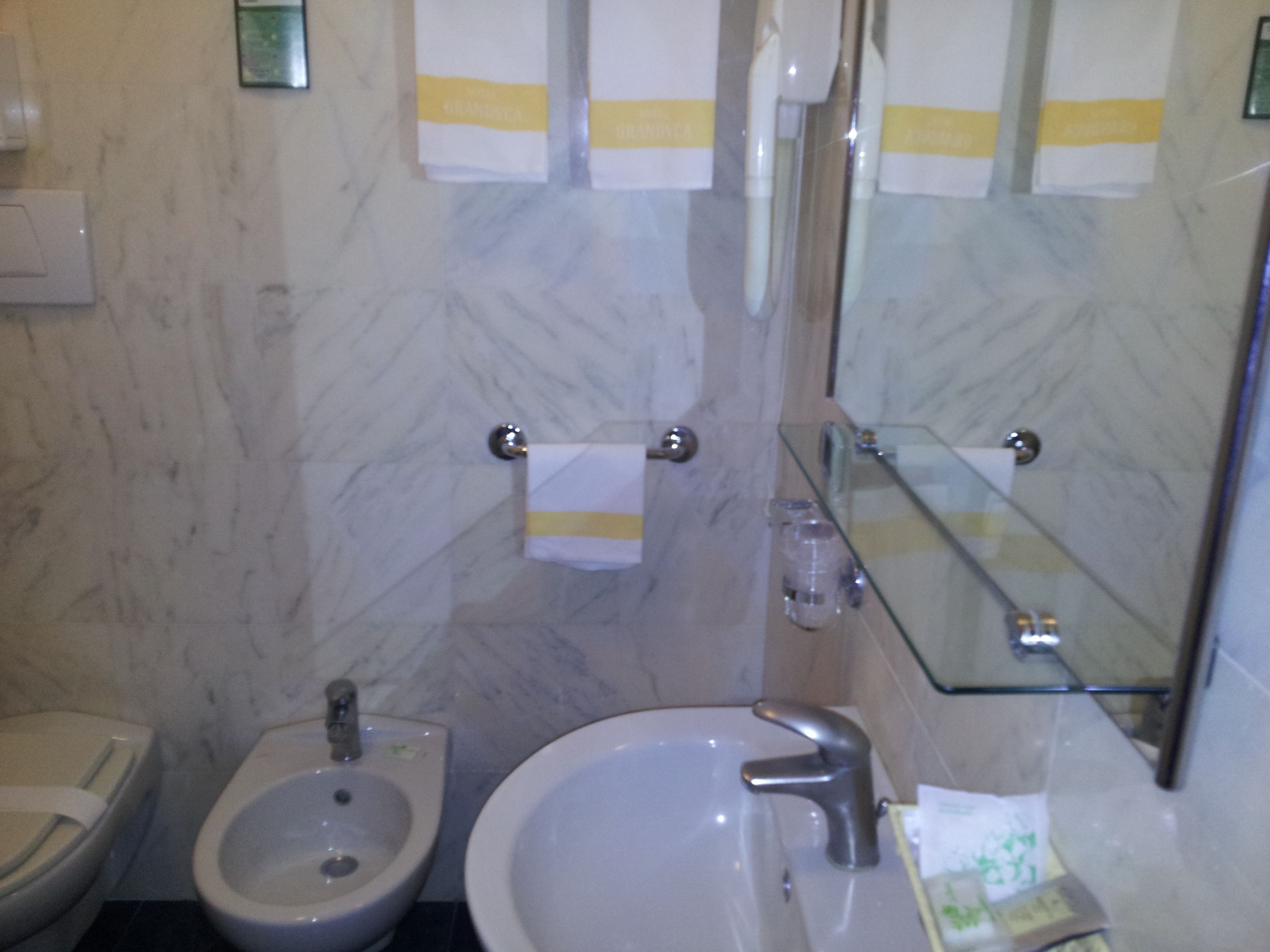 Une salle de bain équipée d’un bidet, d’un lavabo et d’un miroir.