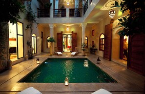 A luxurious indoor swimming pool with multiple levels, elegant lighting, and comfortable seating areas. - Riad Dar Justo Hotel Boutique & Spa (Marrakech)