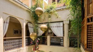 Un patio con piscina, varios balcones y abundante vegetación.