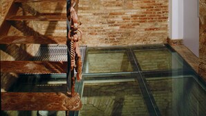 A staircase with a metal handrail and a wooden sculpture. - AinB Gothic-Jaume I Apartments (Barcelona)