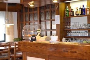 A bar area with wooden shelves, a cash register, and a display case.