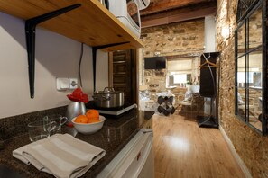 Una cocina con encimeras de granito, estufa, lavamanos y un tazón de naranjas.