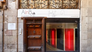 A building with a wooden door and a glass entrance. - AinB Picasso Corders Apartments (Barcelona)