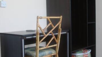 A room with a desk, a chair, and a wardrobe.