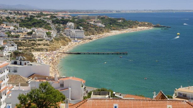 A coastal town with a beach, a pier, and buildings with red-tiled roofs. - Hotel do Cerro (Albufeira)