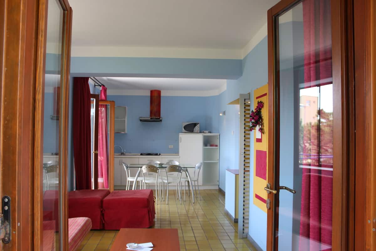 A compact living space with a kitchenette, a dining area, and a small seating area.