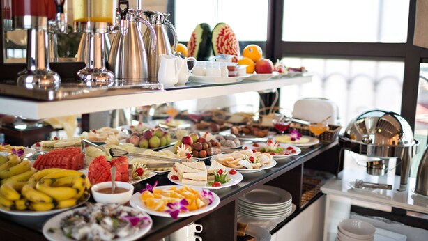 A buffet with a variety of fruits, sandwiches, and beverages. - Hanoi Golden Moon Hotel (Hanoi)