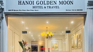 The entrance of Hanoi Golden Moon Hotel & Travel with a reception desk, a chandelier, and framed pictures on the walls. - Hanoi Golden Moon Hotel (Hanoi)