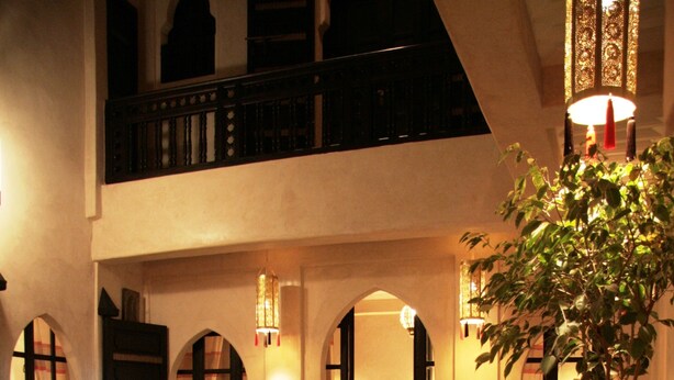 Un espace intérieur accueillant, comprenant un coin repas, une plante en pot et un escalier menant à un niveau supérieur.