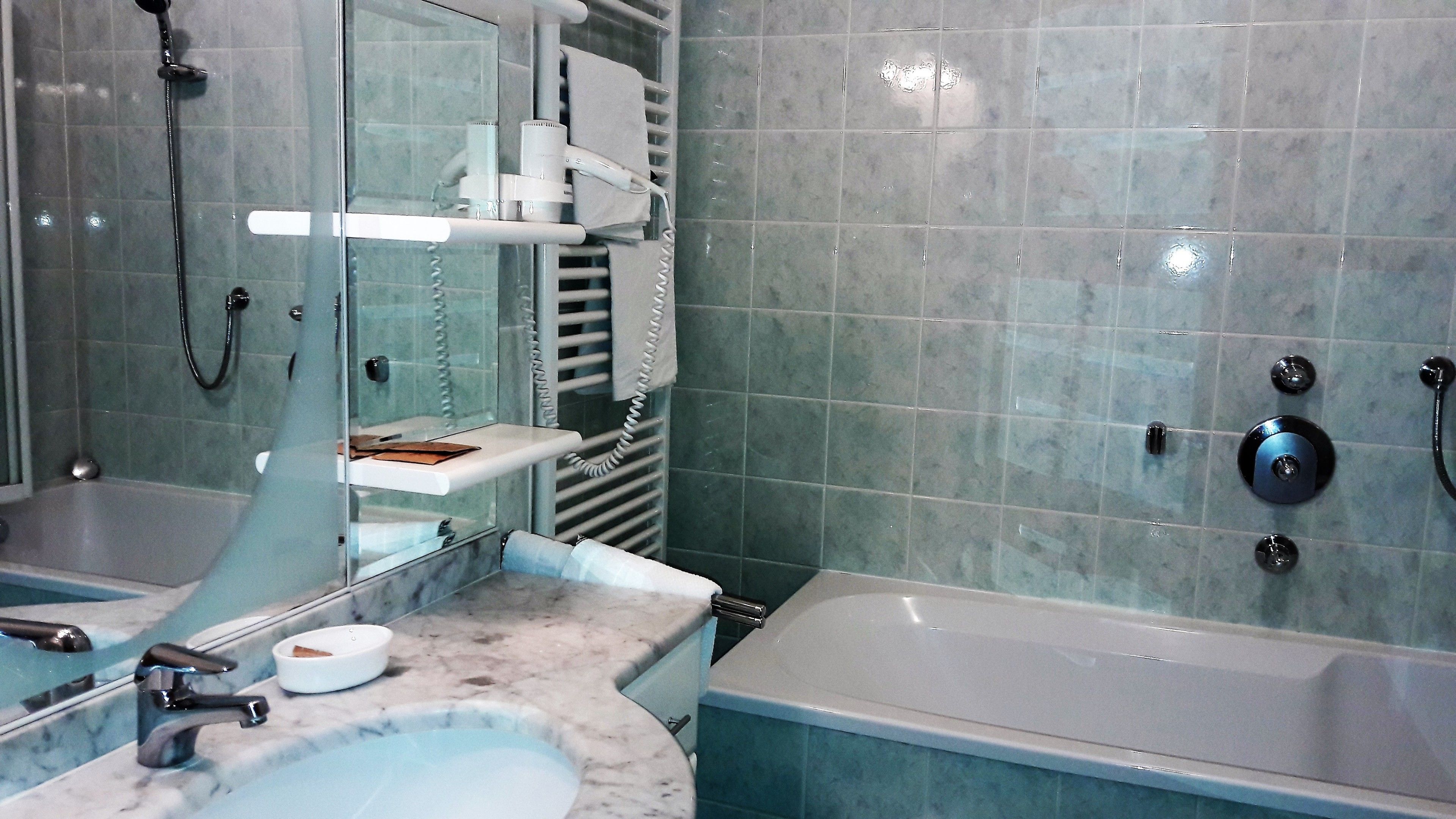 A bathroom with two sinks, a bathtub, and a shower.