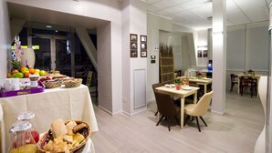 Un comedor con una mesa de buffet, sillas y una escalera que lleva a otra habitación.