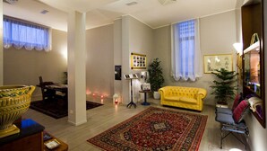 Una sala de estar con un sofá amarillo, una alfombra grande y un comedor con una mesa y sillas.