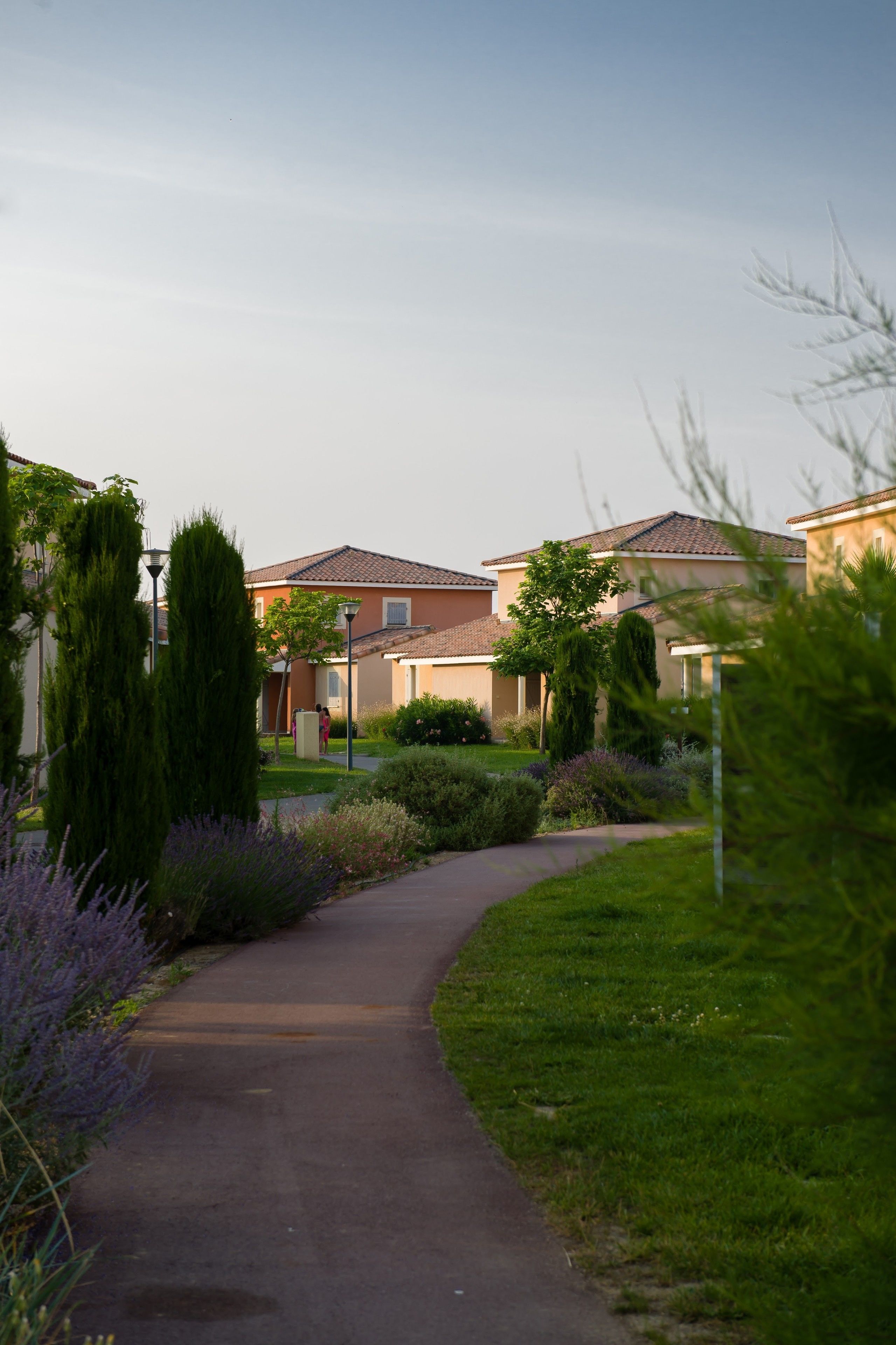 Un área residencial con un sendero pavimentado que lleva a casas con techos de tejas.