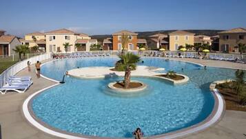 Relax by the pool surrounded by palm trees and lounge chairs.