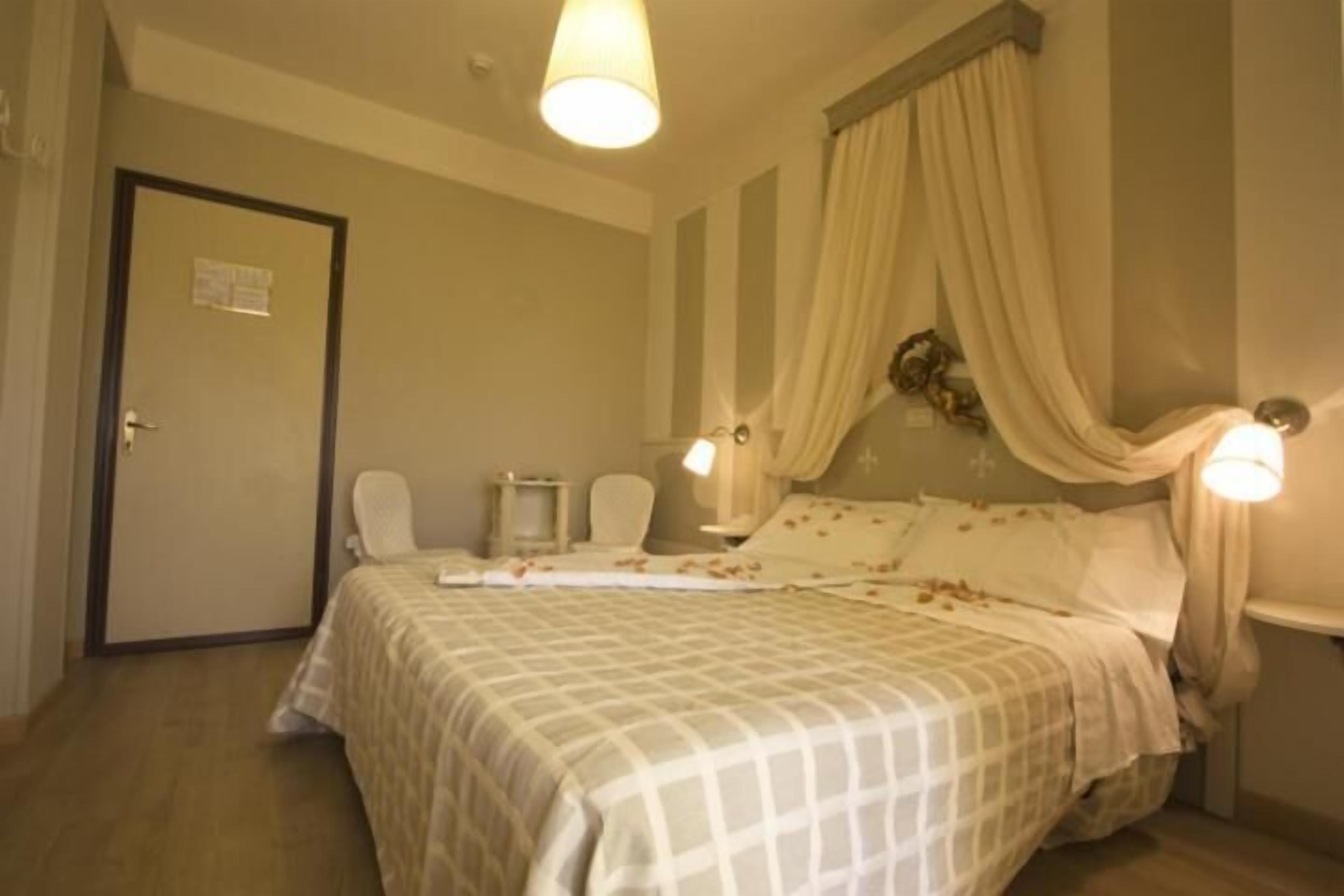 A bedroom with a bed, a nightstand, a chair, and a door.