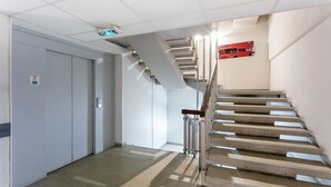 A modern interior with a staircase, a door, and a wall-mounted sign.