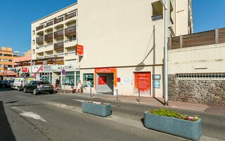 Un immeuble à étages, avec une entrée au niveau du sol et une enseigne indiquant « LE SAINT CLAIR ».
