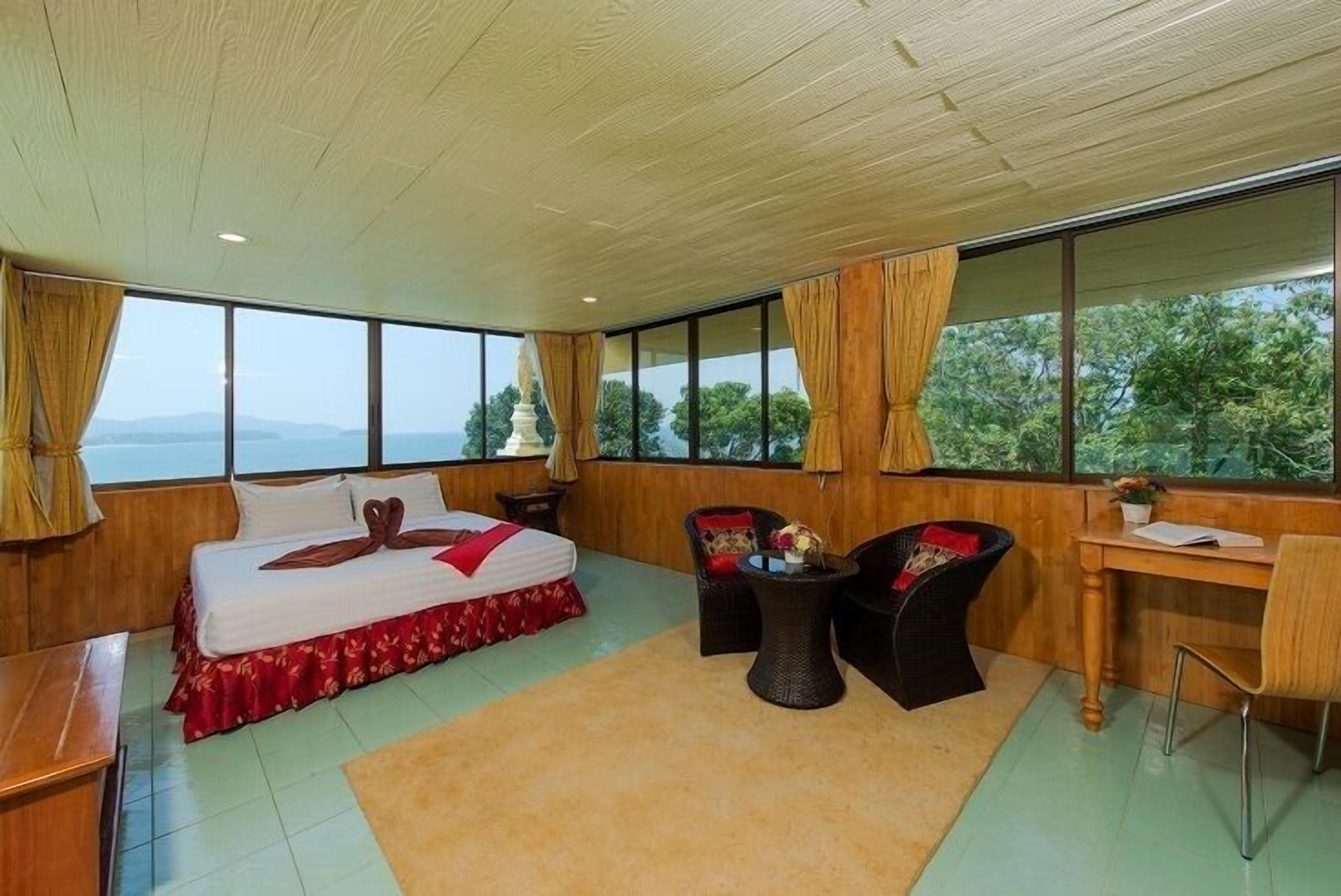 Habitación de hotel con una cama grande, dos sillas, una mesita y un escritorio.