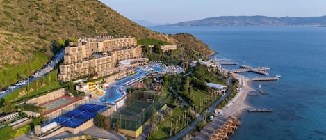 A resort with a large building, a swimming pool, and a beach area.
