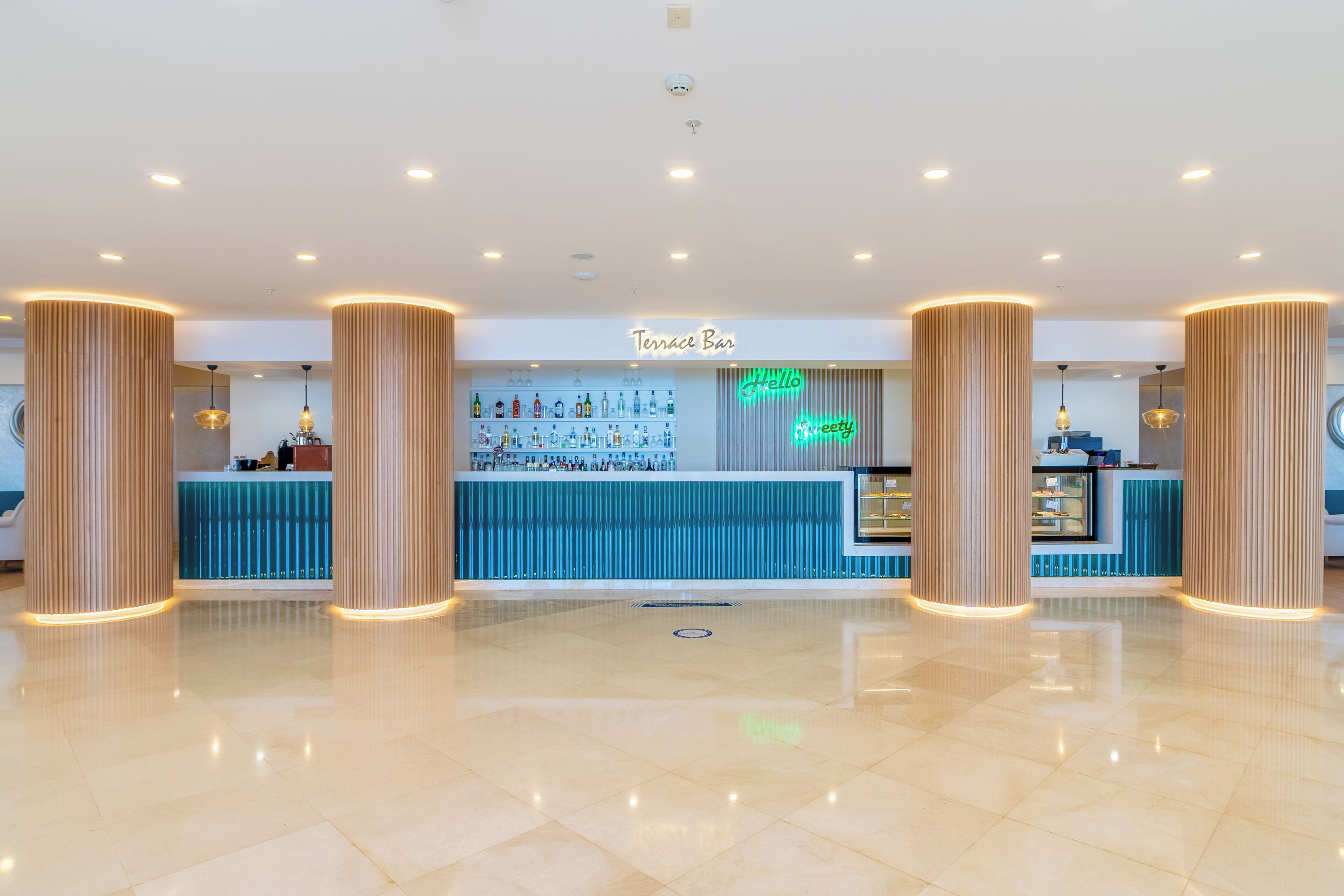 Un área de bar moderna con un letrero de neón, una recepción y una barra.