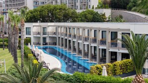 A modern hotel with a swimming pool, multiple balconies, and lush greenery. - Kefaluka Resort - All Inclusive (Bodrum)