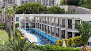 A modern hotel with a swimming pool, multiple balconies, and lush greenery. - Kefaluka Resort - All Inclusive (Bodrum)