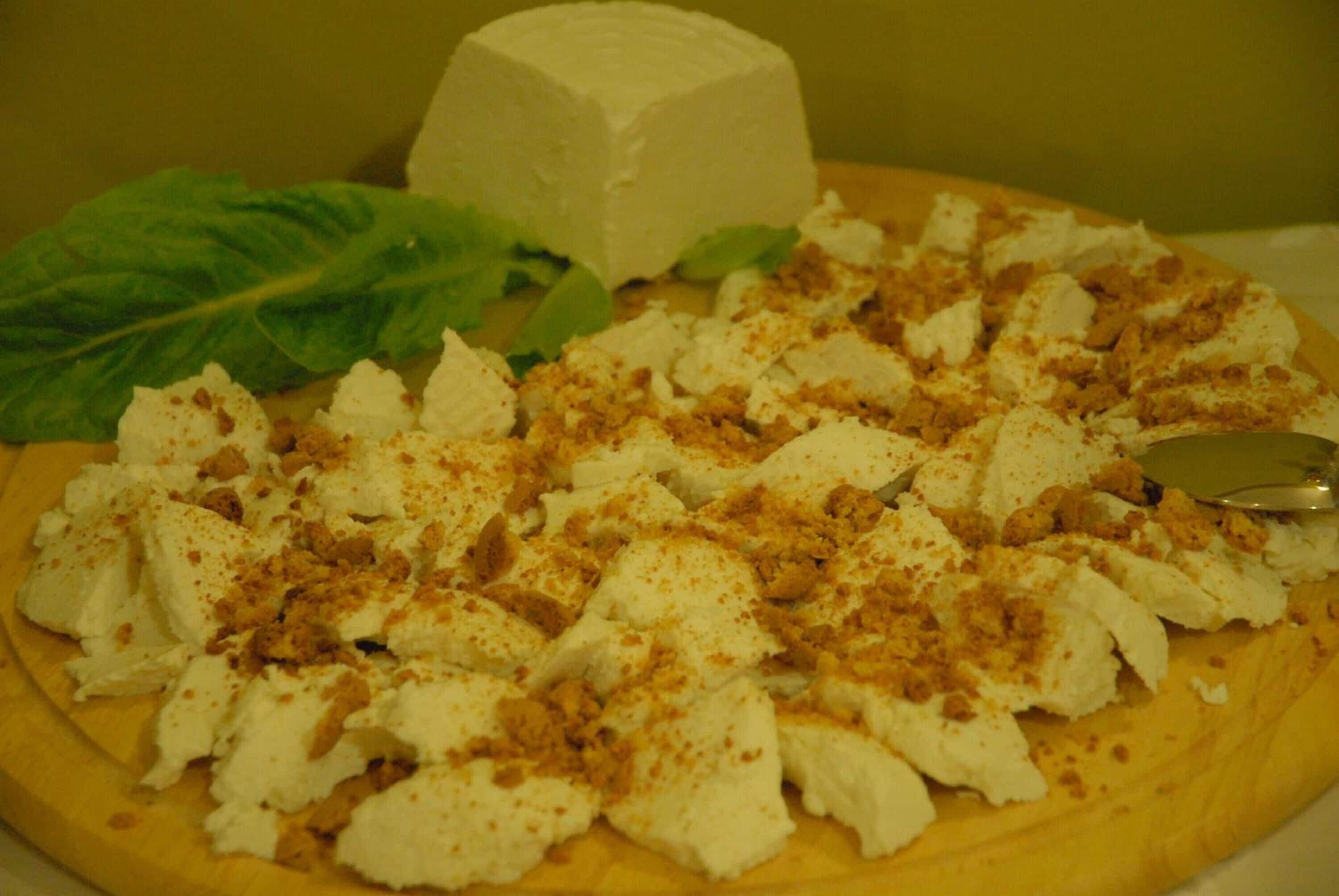 Un plato de comida con queso desmenuzado y una hoja de lechuga.