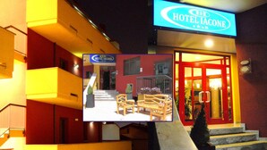 A hotel entrance with a sign reading "HOTEL IACONE," a staircase leading up to the entrance, and a small outdoor seating area with chairs and tables. - Iacone (Chieti)