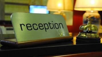 Un mostrador de recepción con un cartel que dice 'recepción' y un timbre.