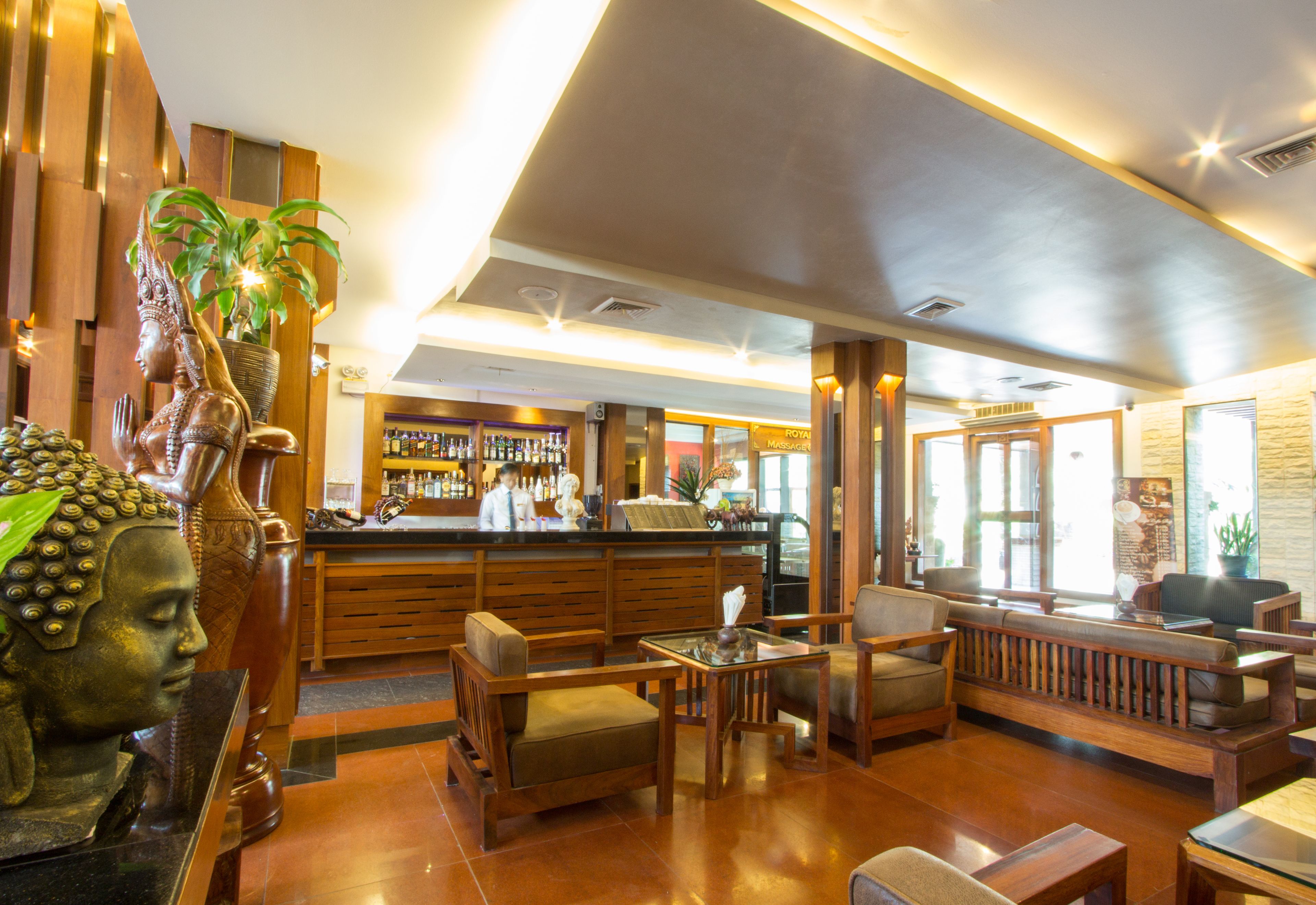 A lobby with wooden furniture, a reception desk, and a bar area.