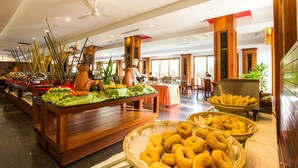 Un espace buffet proposant divers plats et une zone de restauration avec des tables et des chaises.