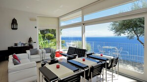 Una sala de estar moderna con balcón con vistas al mar.