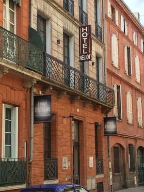 A hotel with a sign reading "Hotel Héliot" and a balcony with decorative iron railings. - Hôtel Héliot, Cosy Places by Charme & Caractère (Toulouse)