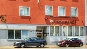 Et hotel med rød facade, mange vinduer og et skilt med teksten "Ehranger Hof".