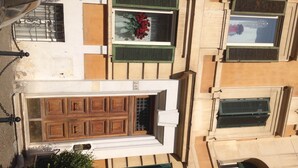A building with a large wooden door, multiple windows with shutters, and a visible number '248'. - Suites Trastevere (Rome)