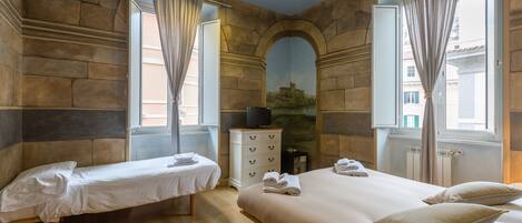 Une chambre d’hôtel avec deux lits, une commode et un téléviseur.